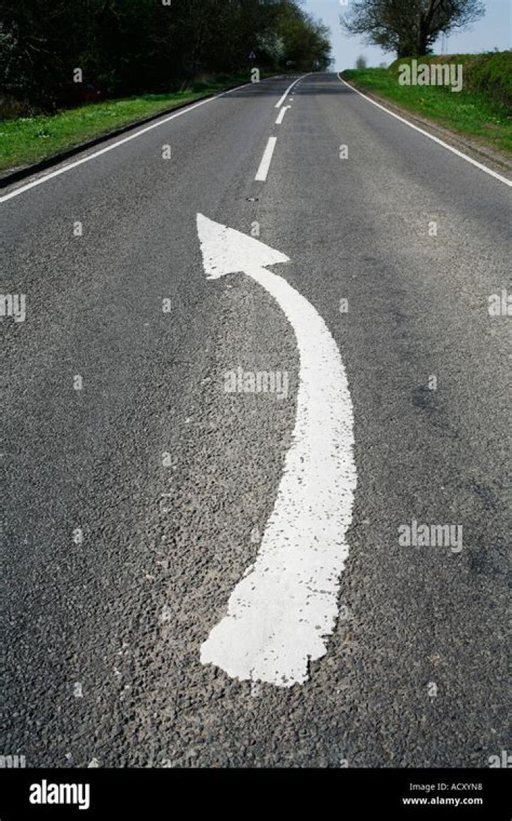 What do white arrows painted on the road indicate?
